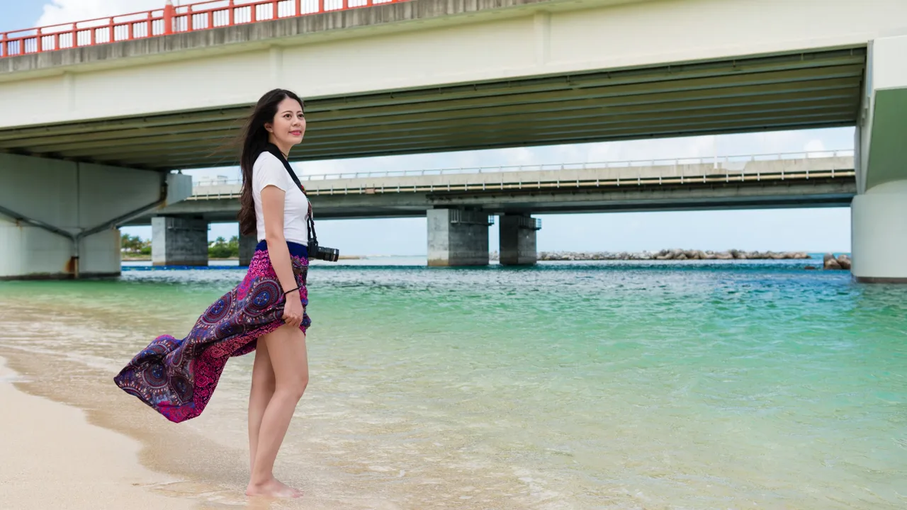 A woman walking on the beach in a flowing wrap