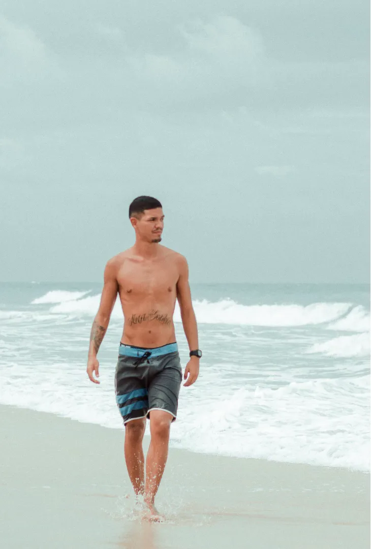 A man walking along the shoreline