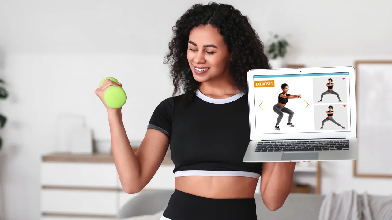 A woman following an online workout on her laptop