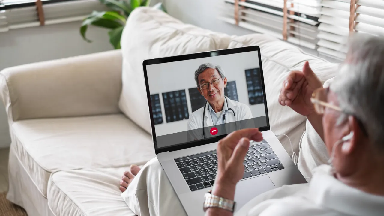 An older man on a video visit with a doctor on his laptop