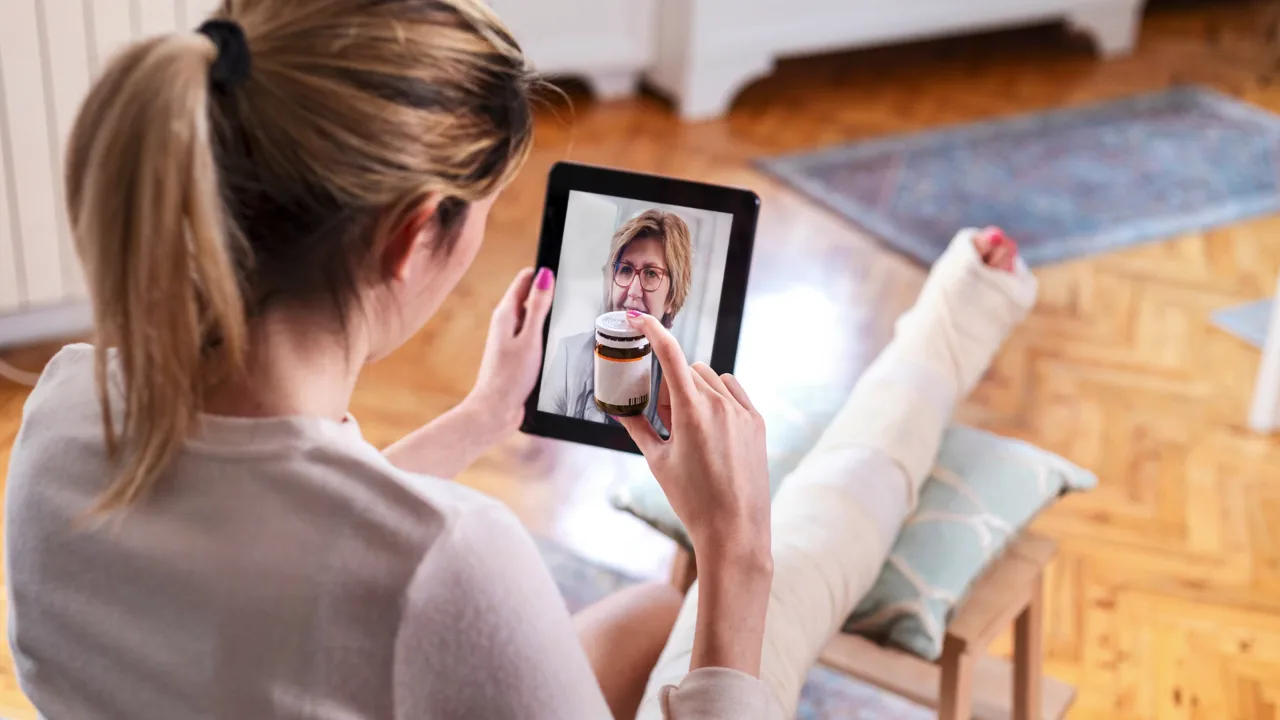A woman holding a tablet during a video visit